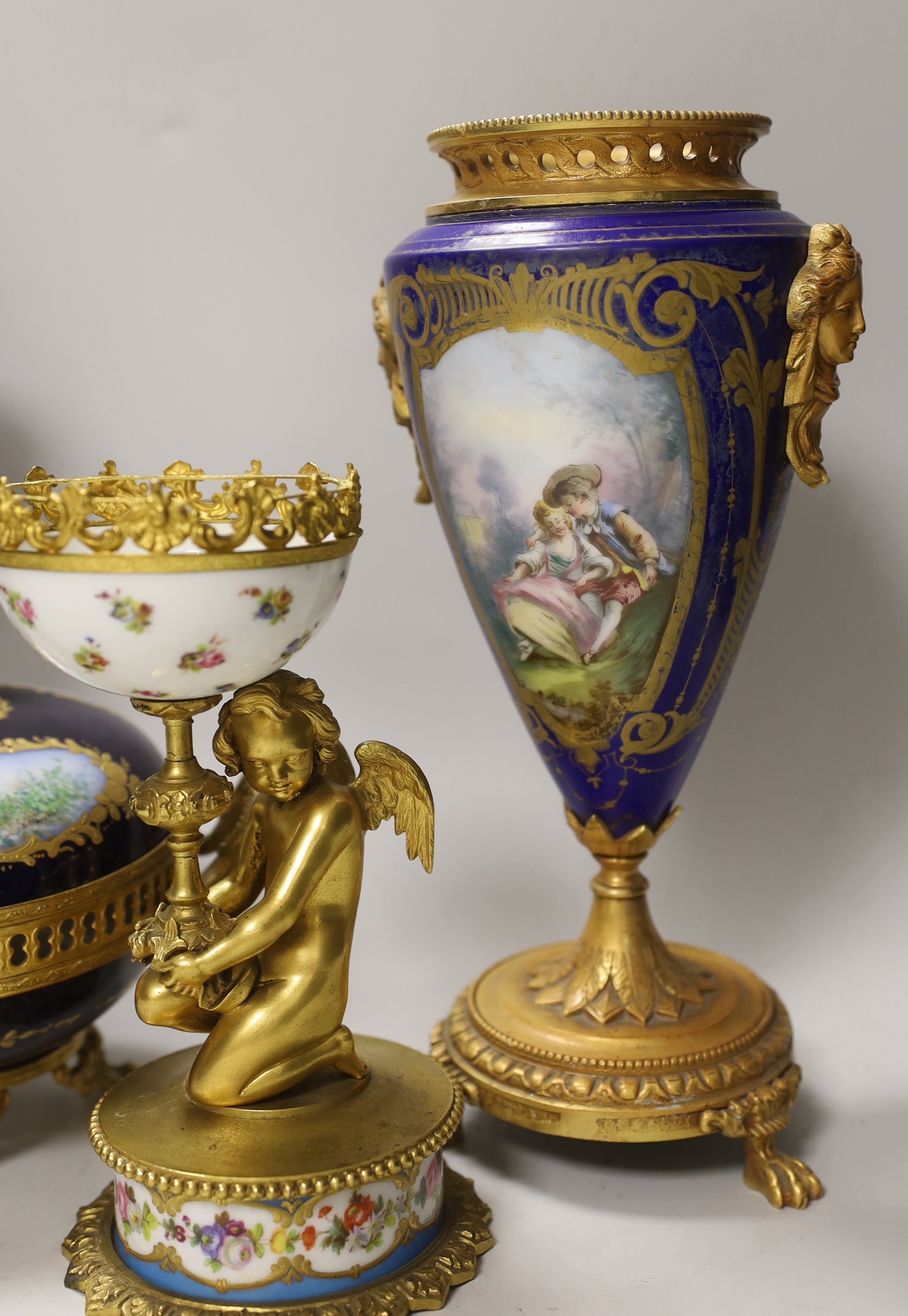 A pair of Sevres style porcelain ormolu mounted vases, a similar putti stemmed cup and a bowl and cover, tallest 27cm